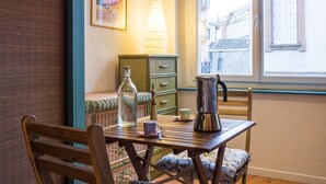 A cozy dining area with a wooden table, chairs, a bottle, a coffee pot, and a lamp. - LE ROSA BONHEUR - One Bedroom Apartment, Sleeps 4 (Toulouse)