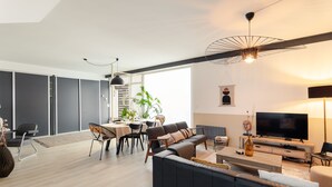 Un soggiorno moderno con divano, TV e zona pranzo.
