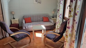 A cozy room with a sofa, two rocking chairs, a small table, and a window with curtains. - GRIZZLY 207- estudi-4 pers- 10m piste-Pas de la Casa -005846 (PAS DE LA CASA)