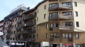 En byggnad med flera våningar och balkonger, en skylt med texten ”Sportman” och en skylt med siffran ”3” som anger byggnadens adress.