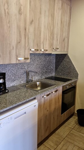 A kitchen with wooden cabinets, a granite countertop, a stainless steel sink, a built-in oven, and a dishwasher. - 505 SKY -Apt 1 hab- 4 pers-Pas de la Casa-10 m pistes -005632 (PAS DE LA CASA)
