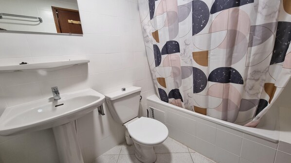 Een badkamer met een wastafel, toilet en douchegordijn.