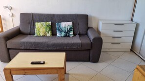 A grey sofa with leaf-patterned cushions, a wooden coffee table, and a white dresser with drawers. - CANIGOU 67-estudi- 4 pers.-piste- Pas de la Casa -006053 (PAS DE LA CASA)