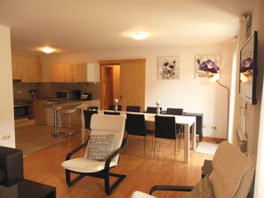 A modern kitchen with wooden cabinets and a dining area with a table and chairs.