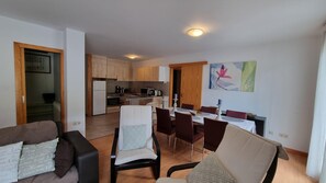 A modern apartment with a dining area, kitchen, and living room.