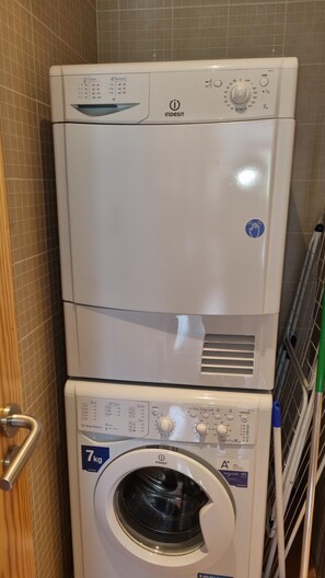 Una lavadora y secadora apiladas, con panel de control, etiqueta de capacidad de 7 kg e indicador de equilibrio de agua.