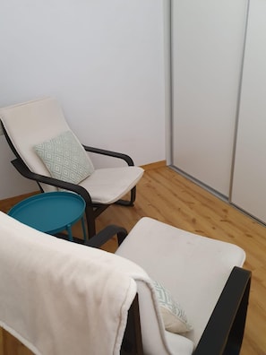A corner room with two chairs, one with a patterned cushion and another with a plain cushion, and a small blue table. - JULIA 2/5-103 m²- 2 hab- 7 pers. balco- EL TARTER -06691 (SANT PERE DEL TARTER)