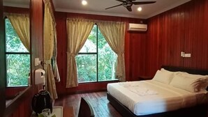 Ein Zimmer mit einem Bett, einem Schreibtisch, einem Stuhl und einem Deckenventilator.
