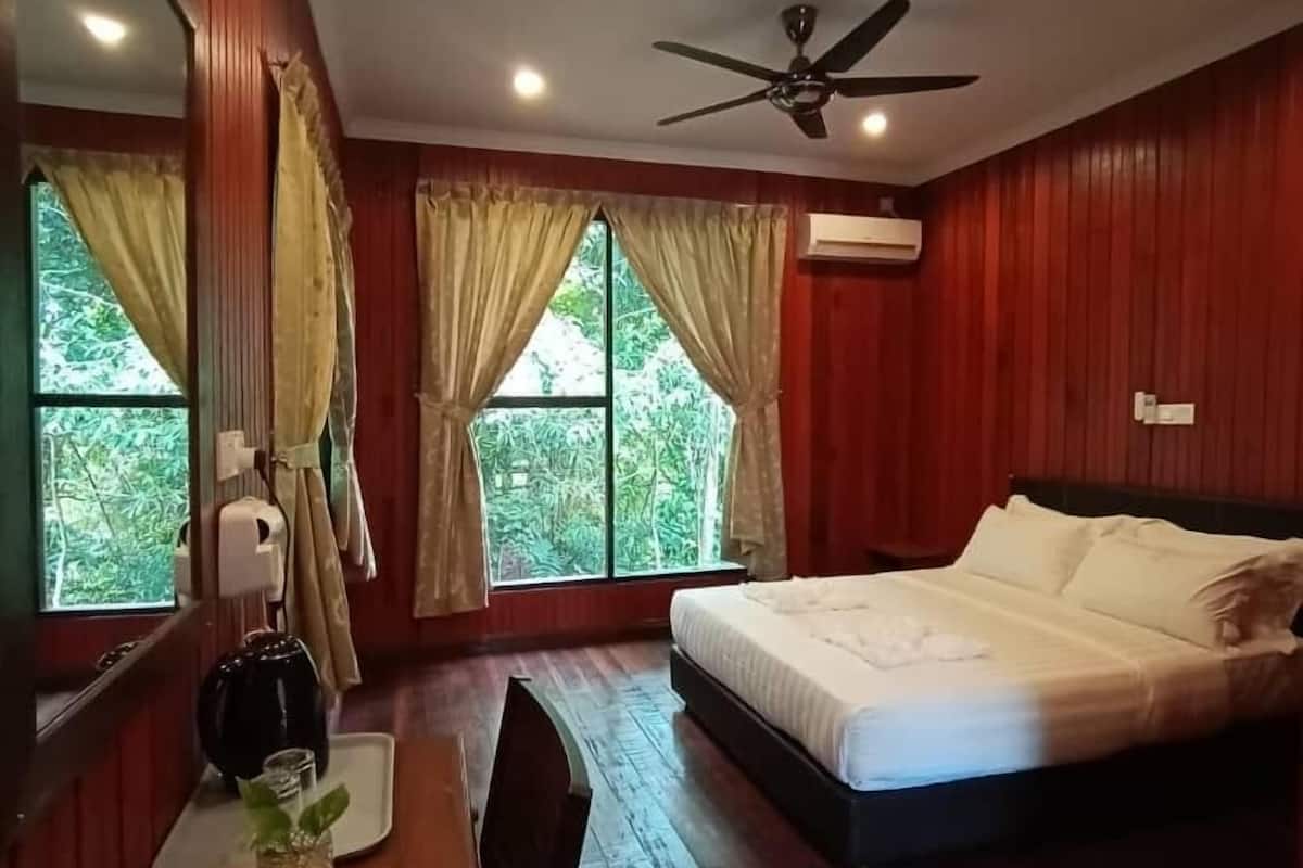 Une pièce comprenant un lit, un bureau, une chaise et un ventilateur de plafond.