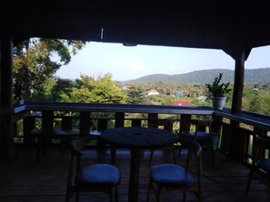 Terraza al aire libre con mobiliario de madera y plantas en macetas.