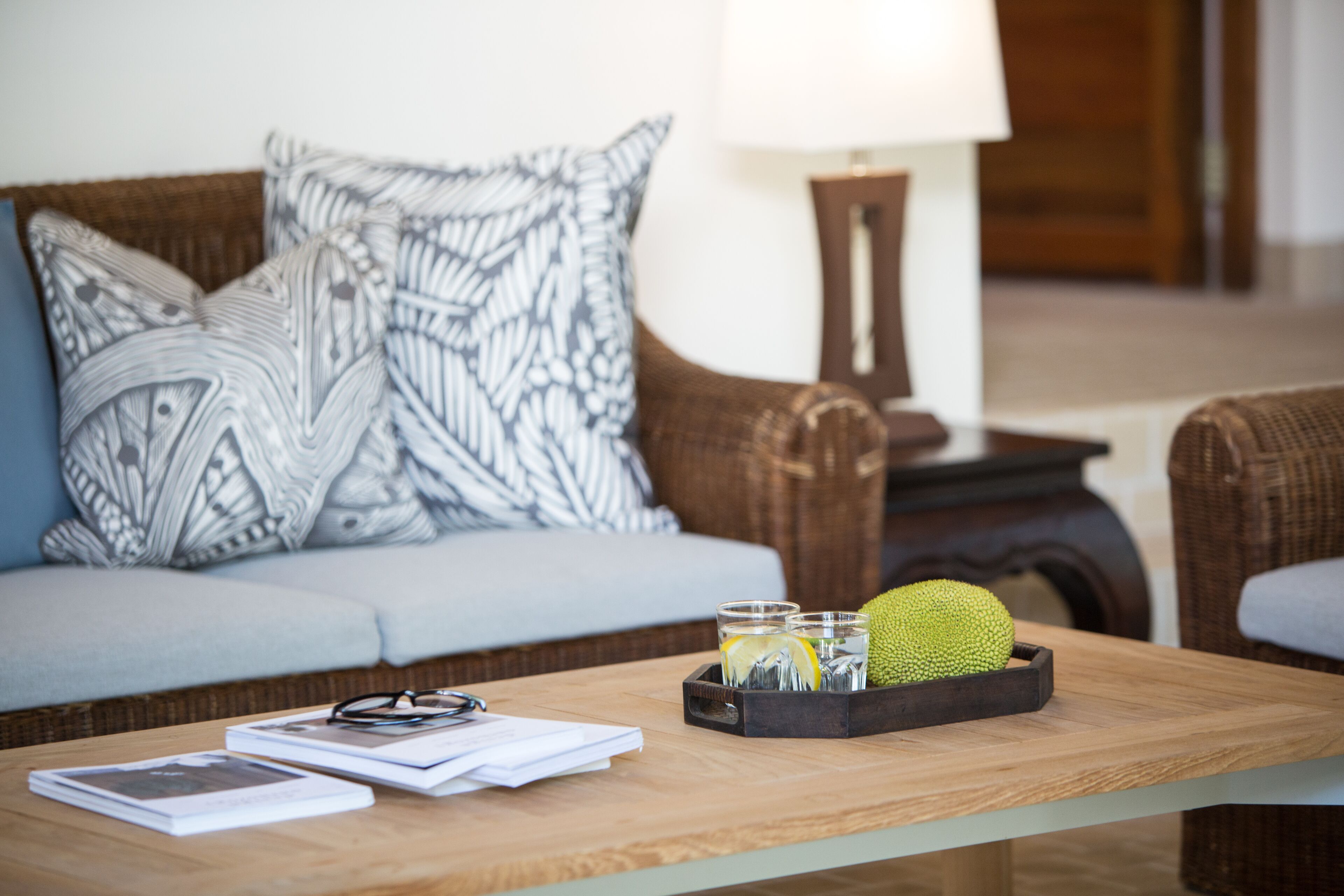 A living room with a sofa, a coffee table, and a lamp.