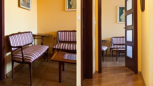 Una stanza con due divani a righe, un tavolino e una porta che dà su un'altra stanza.