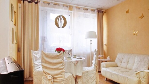 A room with a piano, a dining table with chairs, a sofa, and a window with curtains. - FeWo Borkum in Papenburg (Papenburg)