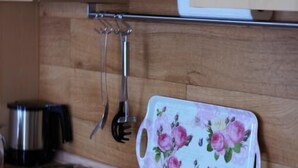 A kitchen with wooden cabinets, a stainless steel stove, and a floral-patterned cutting board. - FeWo Borkum in Papenburg (Papenburg)
