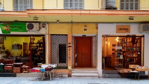 Fachada com porta de madeira e janela com grade de metal.