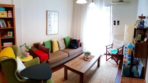 Uma sala de estar com sofá, poltronas, mesa de centro e rack para televisão.