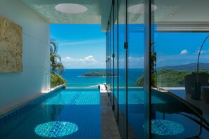 Ein moderner Infinity-Pool mit freiem Blick auf das Meer und eine tropische Landschaft.