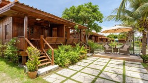Une maison en bois avec un porche, un espace salon extérieur et une terrasse en pierre.