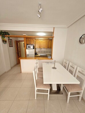 A modern kitchen with wooden cabinets, a microwave, and a sink. - Beautiful bright apartment 5 min walk from the beach and shops (Torrevieja)