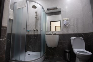A modern bathroom with a glass-enclosed shower, a white sink, and a toilet. - Boutique Living Hotel (Yerevan)