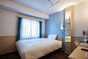 Ein Hotelzimmer mit Bett, Schreibtisch, Stuhl, einem Fenster mit Vorhängen, einer Wandleuchte und einer Uhr.