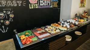 A buffet with various food items and a chalkboard with breakfast-related drawings.
