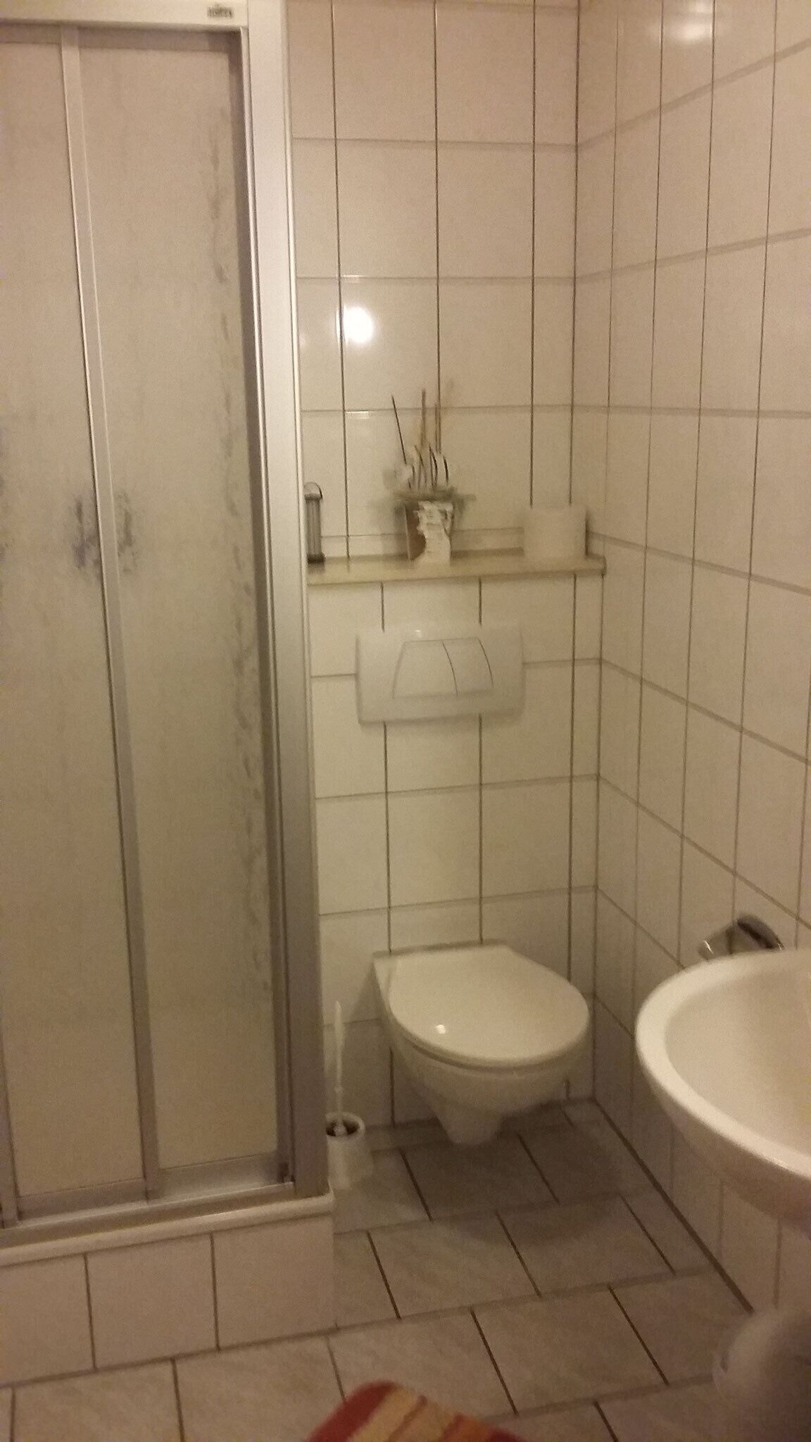 A bathroom with a toilet, sink, and shower.
