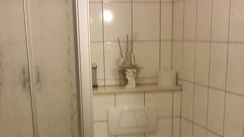 A bathroom with a toilet, sink, and shower.