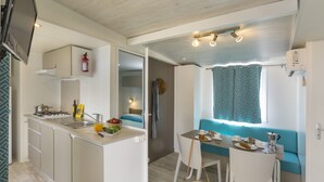 Una cocina compacta con comedor, estufa integrada y una pequeña mesa con sillas.
