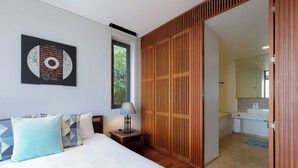 A hotel room with a bed, a nightstand, a lamp, a wooden wardrobe, a bathroom with a mirror, and a window. -  The Heights Kata Seaview C1 near Kata Beach (Karon)