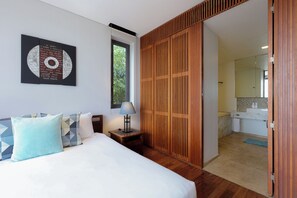 A hotel room with a bed, a nightstand, a lamp, a wooden wardrobe, a bathroom with a mirror, and a window. -  The Heights Kata Seaview C1 near Kata Beach (Karon)