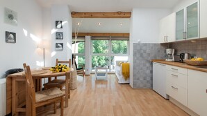 Una cucina moderna con pavimento in legno, mobili bianchi e un lucernario.