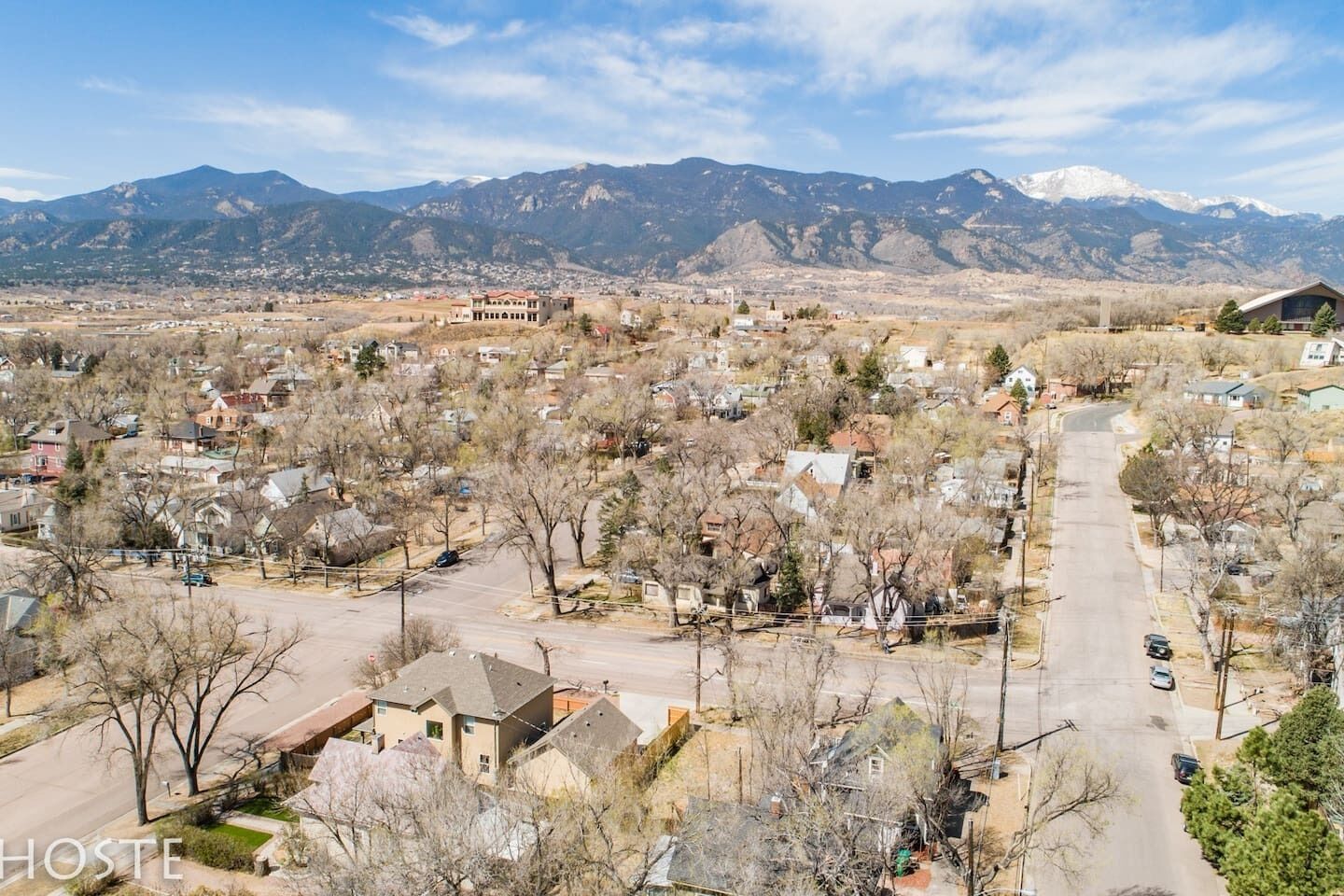 A residential area with houses, a main road, and mountains in the background.
