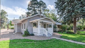 Une maison de plain-pied avec un porche à l’avant, un petit jardin devant et une allée.