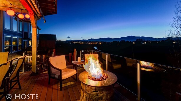 A deck with a stone fire pit, outdoor seating, and a view of the mountains. - 5BR Mtn Views Family Getaway HOT TUB (Colorado Springs)