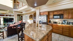 A spacious kitchen with granite countertops, wooden cabinets, and stainless steel appliances. - 5BR Mtn Views Family Getaway HOT TUB (Colorado Springs)