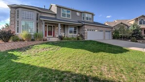A two-story house with a front porch, large windows, and a garage.