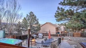 A backyard with a hot tub, barbecue grill, and outdoor seating area. - 4BR Entertainer AF Academy Hot Tub, Firepit! (Colorado Springs)