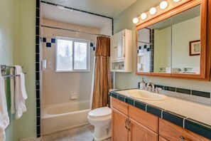 A bathroom with a bathtub, toilet, vanity with a mirror, and a window. - 4BR Dog Friendlygarden of the Godsbbq Grill! (Colorado Springs)