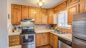 A kitchen with wooden cabinets, stainless steel appliances, and a tiled backsplash. - 4BR Dog Friendlygarden of the Godsbbq Grill! (Colorado Springs)