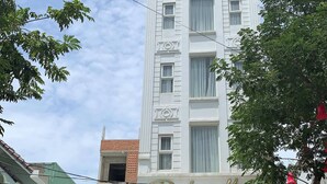 A tall white building with balconies and a sign that reads "Dubai Hotel". - Dubai Hotel (Da Nang)