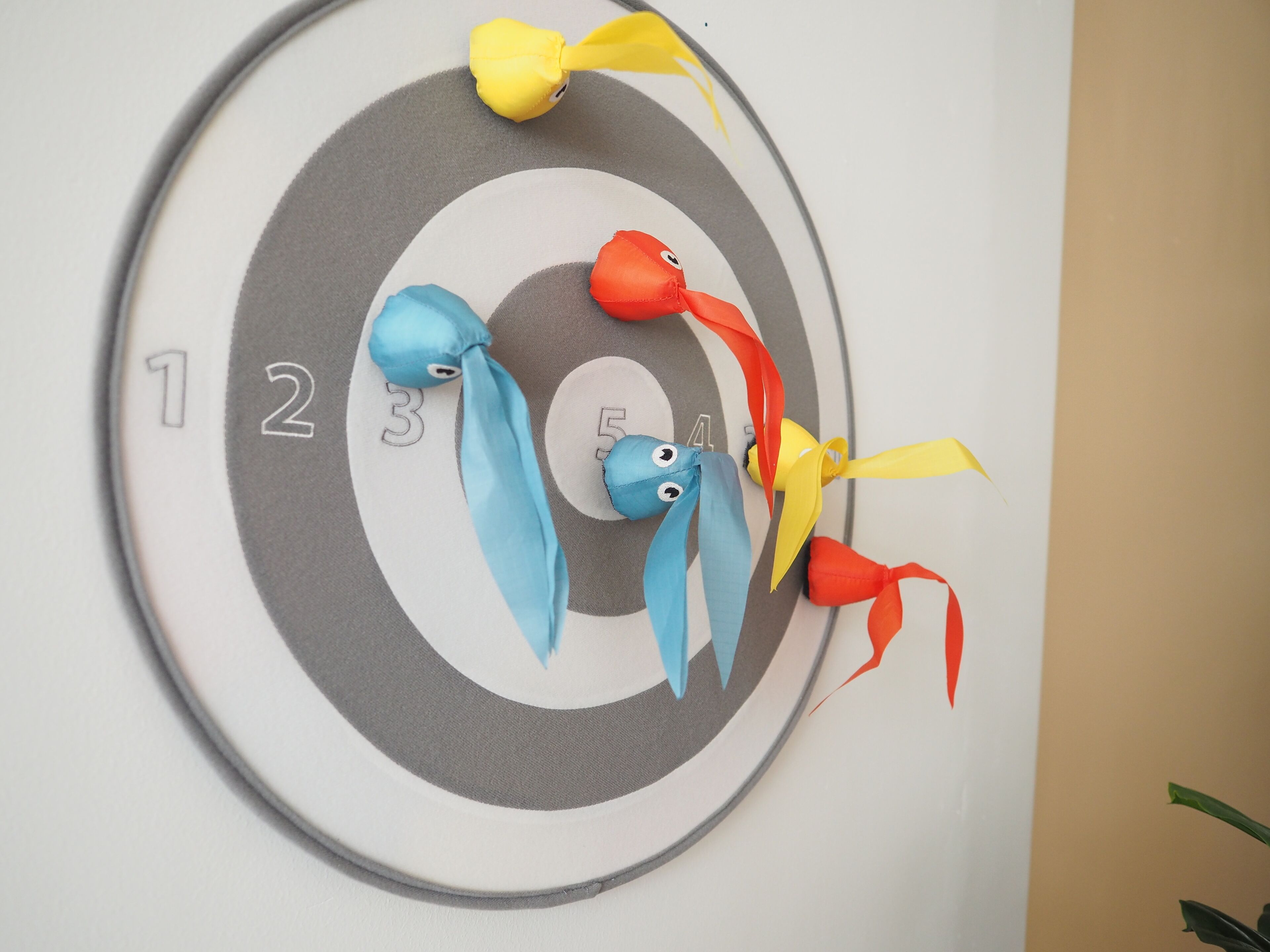 A dartboard with numbered sections and colorful fish decorations.