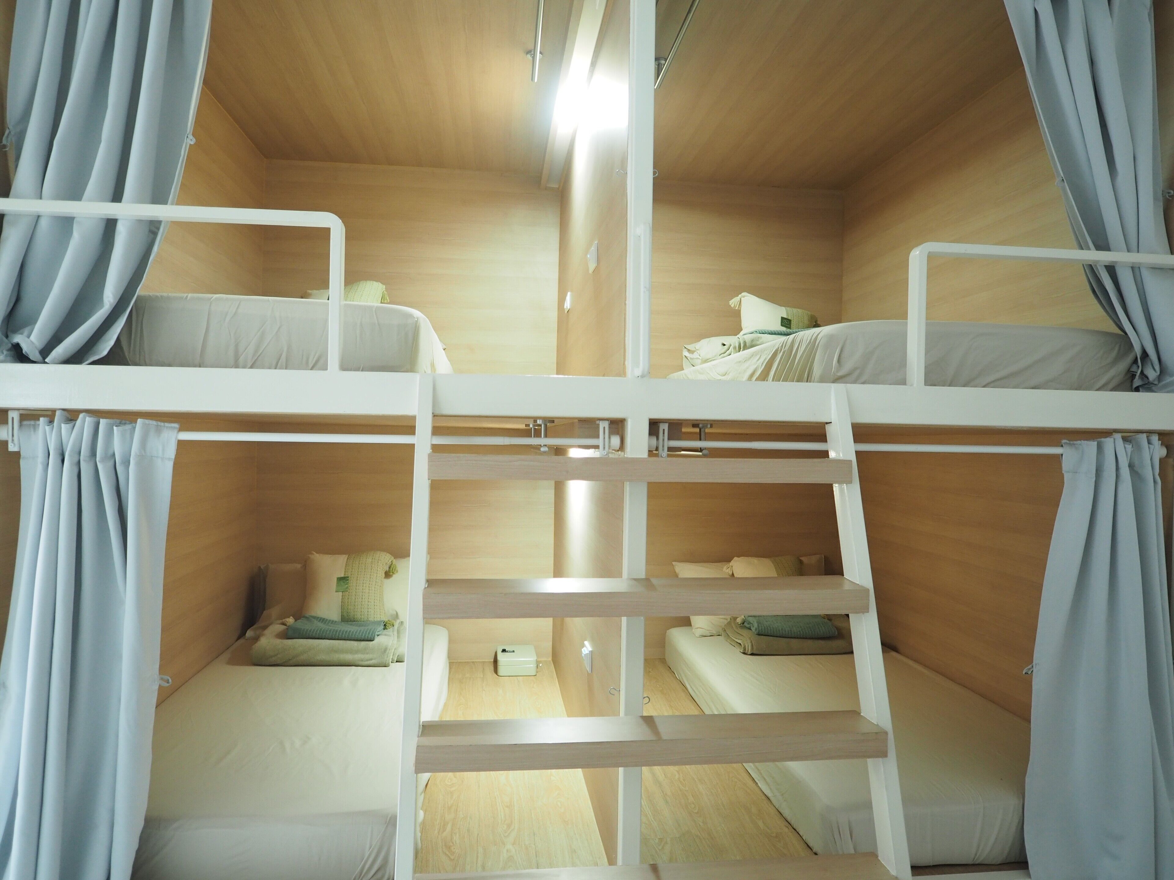A bunk bed room with wooden walls and curtains.