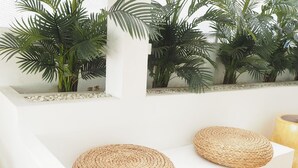 A white reception desk with woven round stools and a potted plant. - Nornnuea at Inthanon (Chom Thong)
