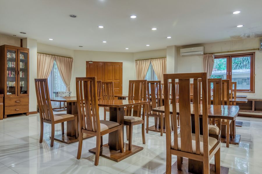 A spacious dining area with wooden furniture and a large window.