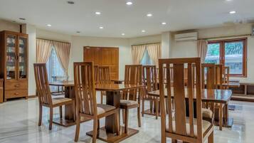 A spacious dining area with wooden furniture and a large window.