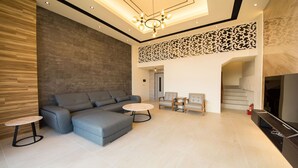 A modern living room with a sectional sofa, two armchairs, a coffee table, and a fireplace. - Yilan Siao Jhu (Jiaoxi)