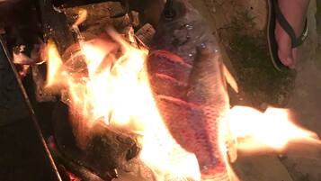 A fish grilling over an open flame.