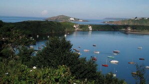 A coastal landscape with a body of water, boats, and buildings.