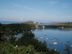 A coastal landscape with a body of water, boats, and buildings.
